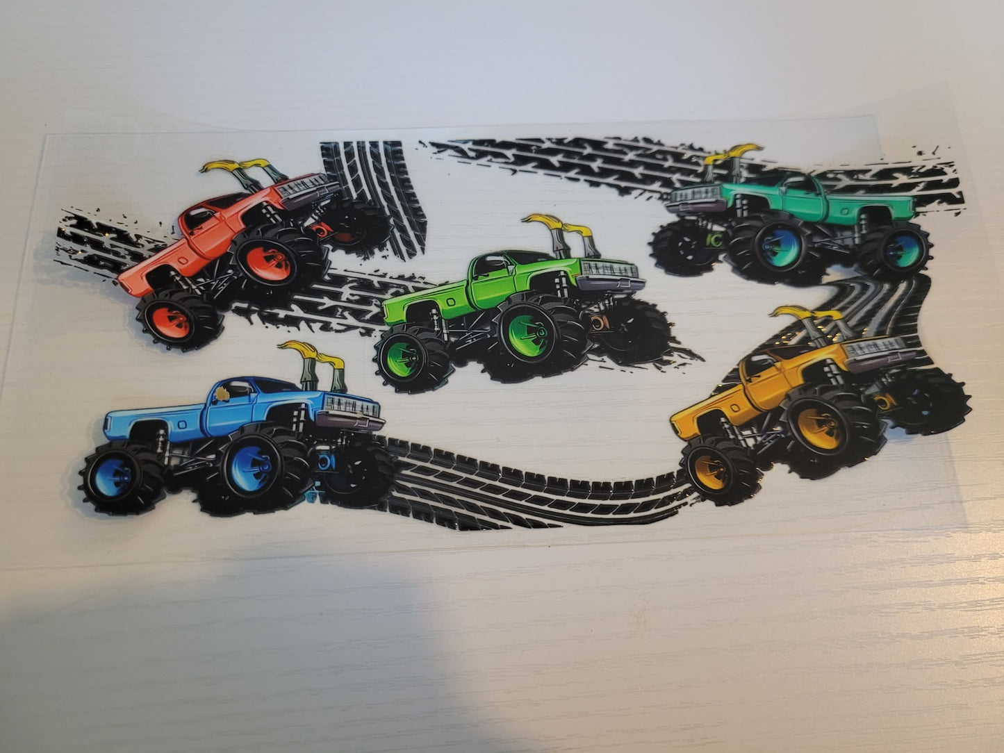 Four toy monster trucks with colorful bodies
