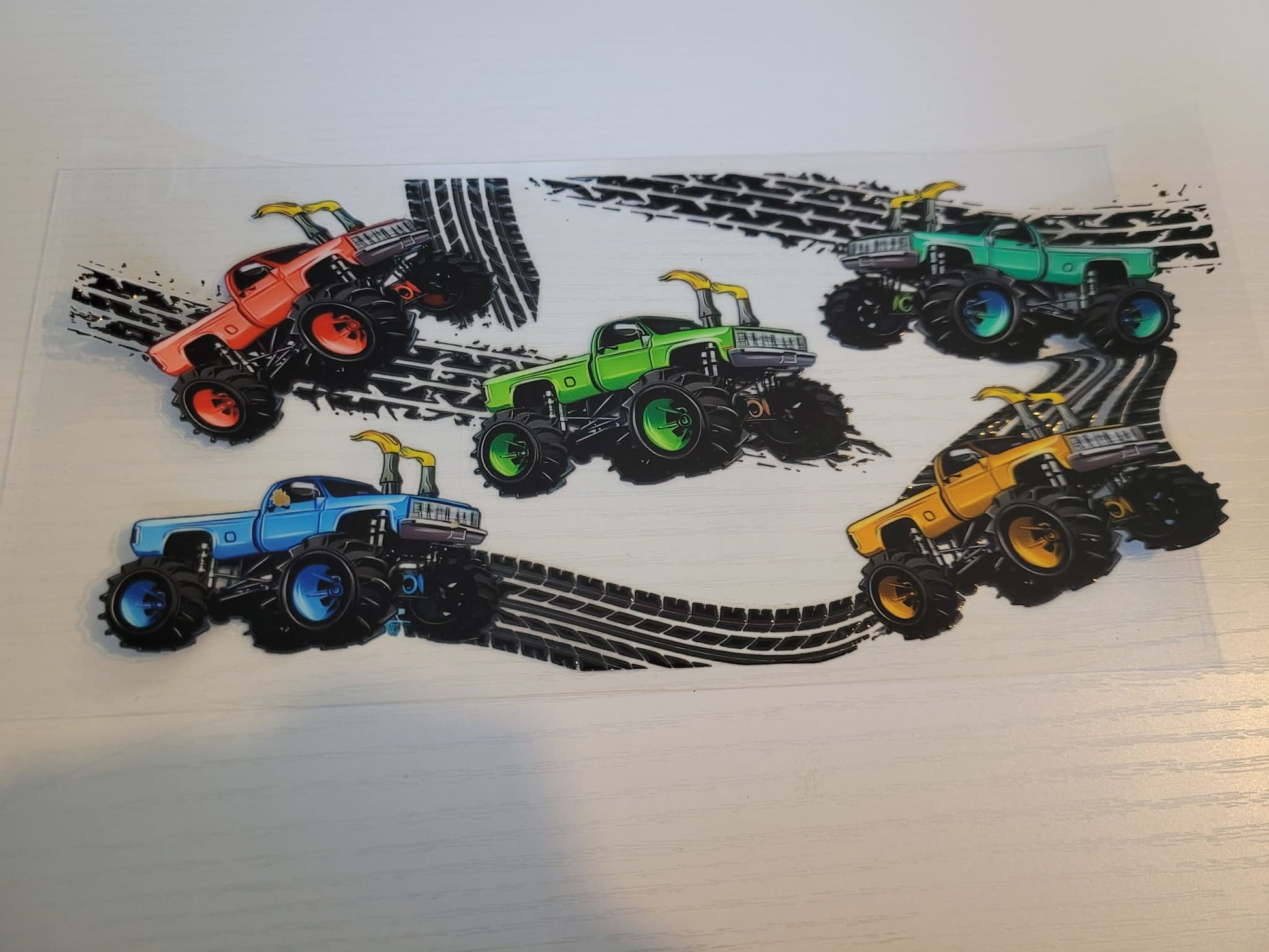 Four toy monster trucks with colorful bodies